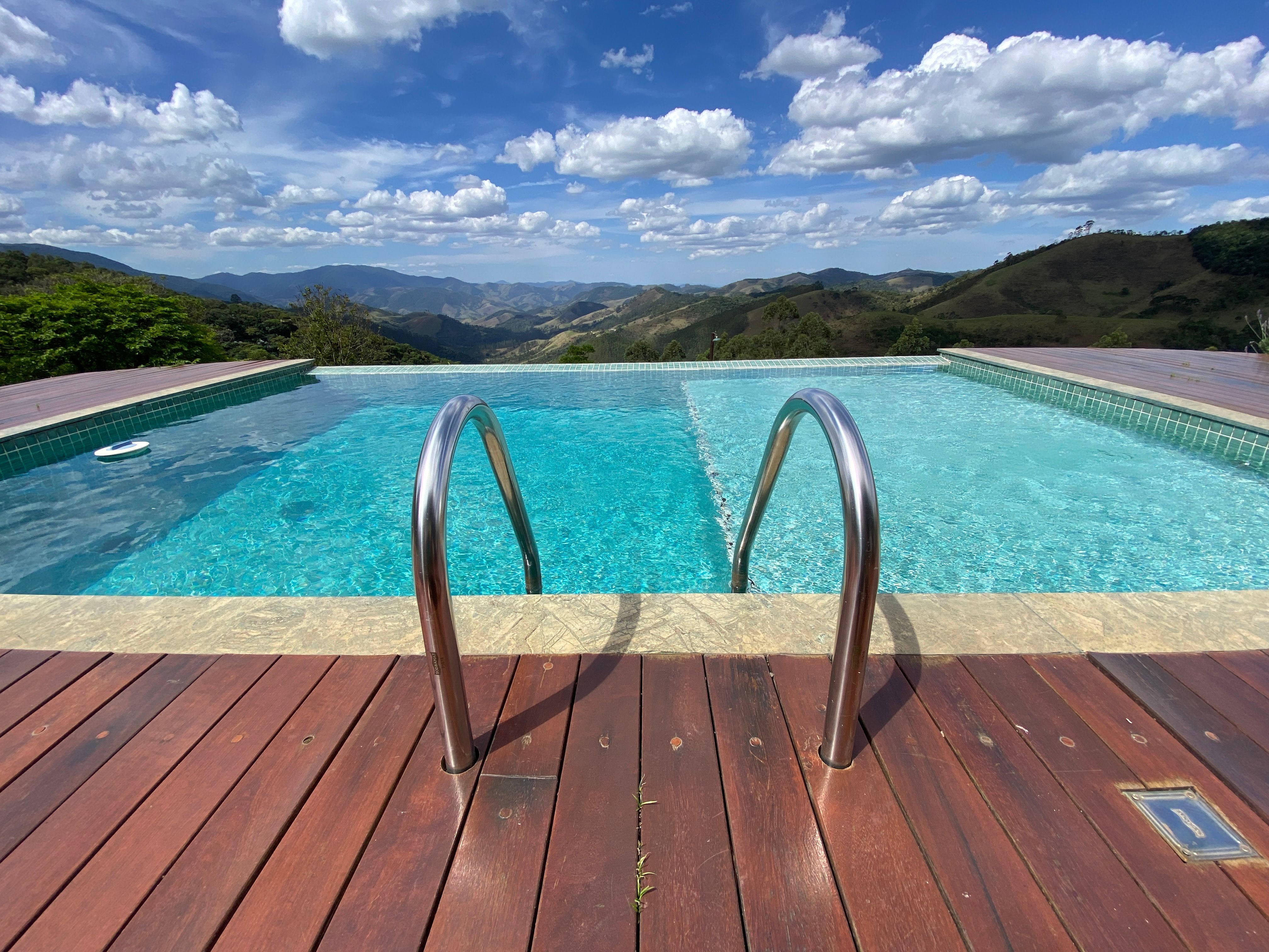 Infinity pool with a view of São Francisco Xavier mountains and blue sky.