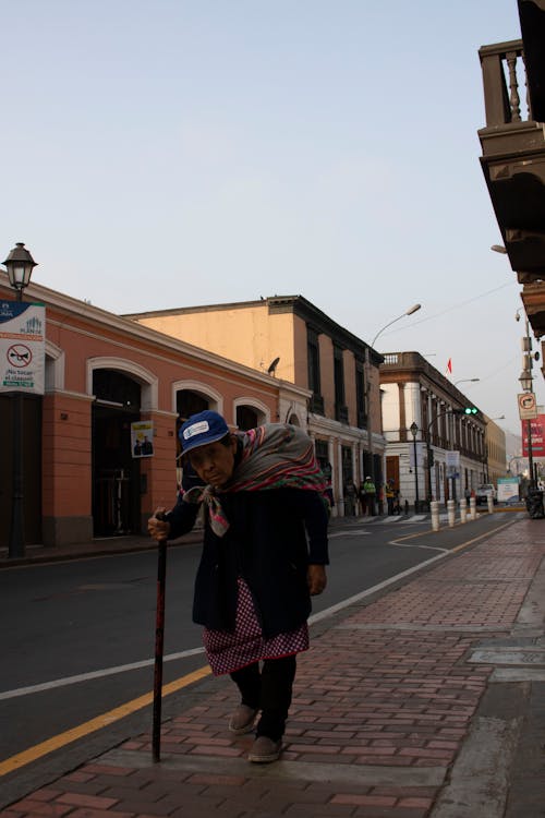 Elderly Woman Walking on Sidewalk