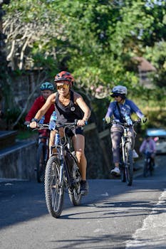 Group of cyclists riding on a sunny road in Denpasar, Bali, Indonesia.
