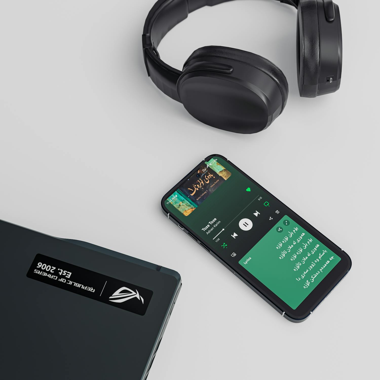 A flat lay of a smartphone, laptop, and headphones showcasing a sleek tech setup.
