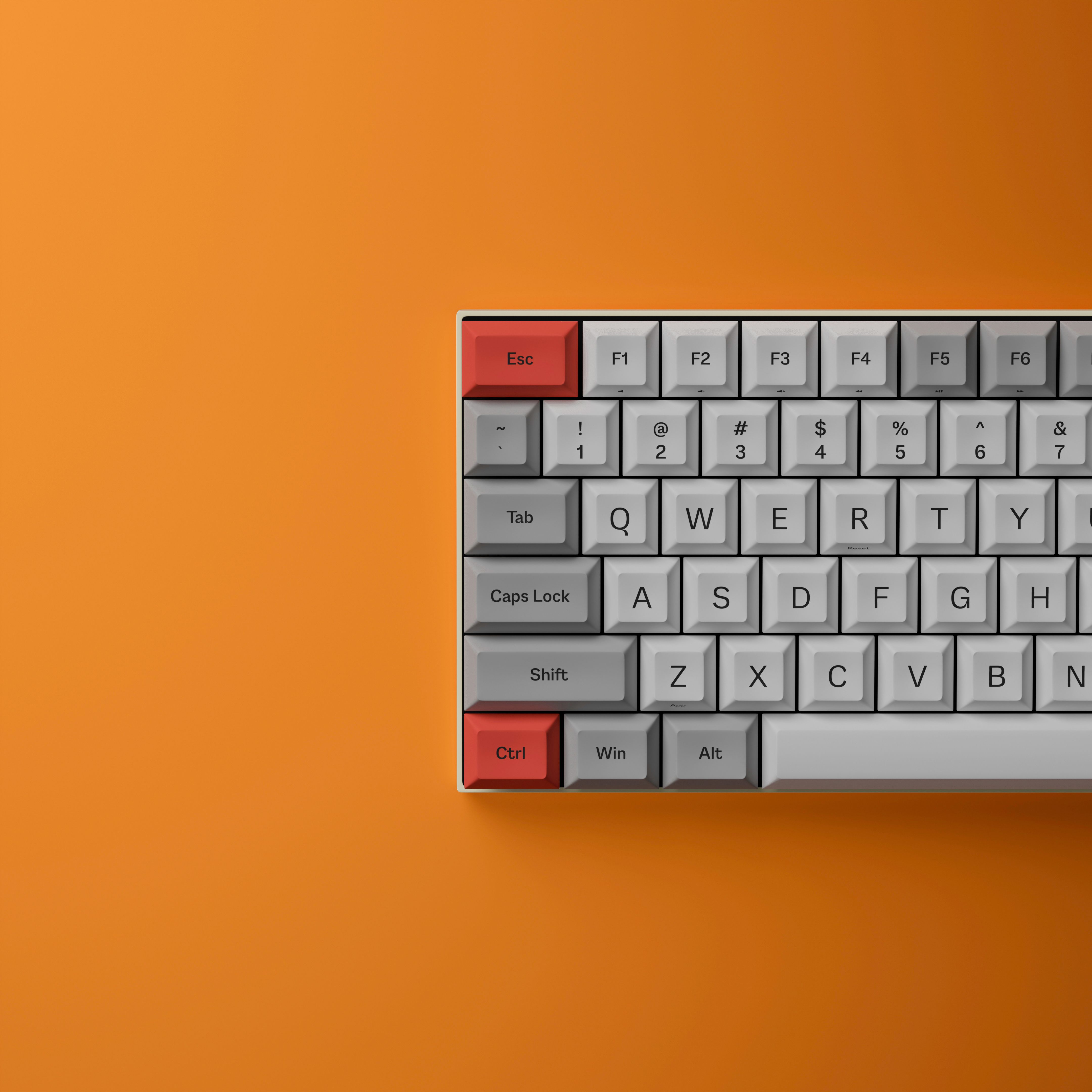 A mechanical keyboard with red and gray keys on an orange background, showcasing sleek design.