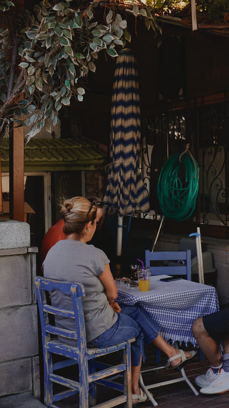 People Sitting At A Table On The Porch