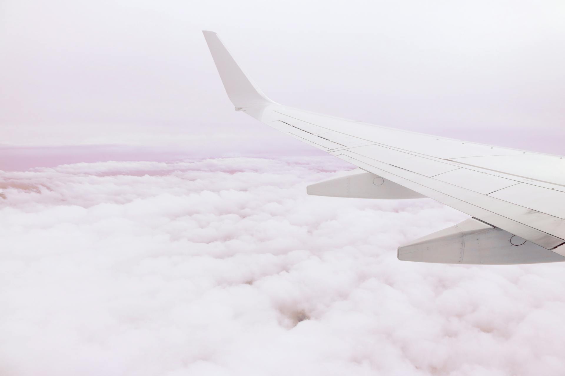 A serene view of an airplane wing cruising above the clouds, showcasing the beauty of aerial travel.