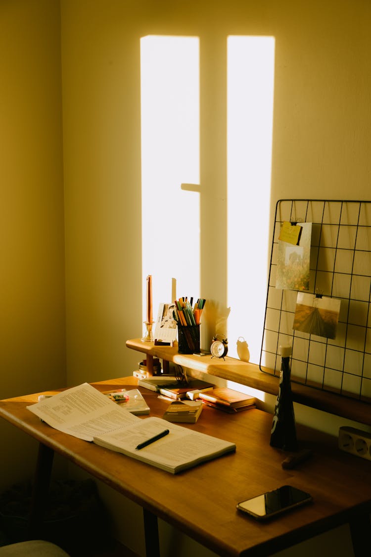 The Sun Shining On A Wall And Desk In A Room