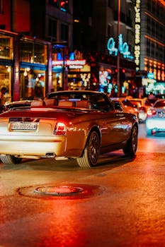A luxurious convertible car drives through the lively streets of Ankara at night, capturing the vibrant nightlife.