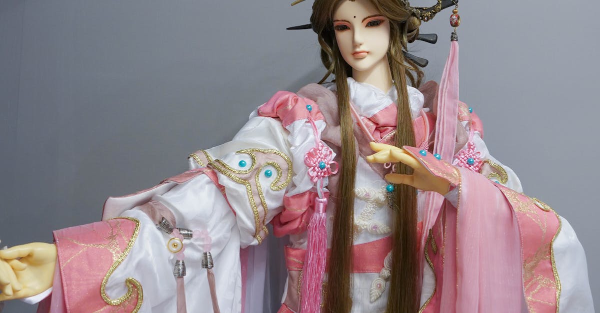 Exquisitely detailed traditional figurine adorned in pink and white attire with intricate embellishments.