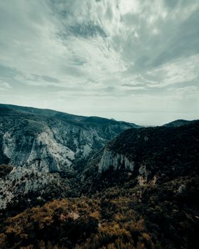 Stunning summer view of rugged mountains with cloudy sky, ideal for nature themes.