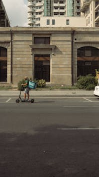 Electric scooter rider delivering food on a city street in Baku, Azerbaijan.