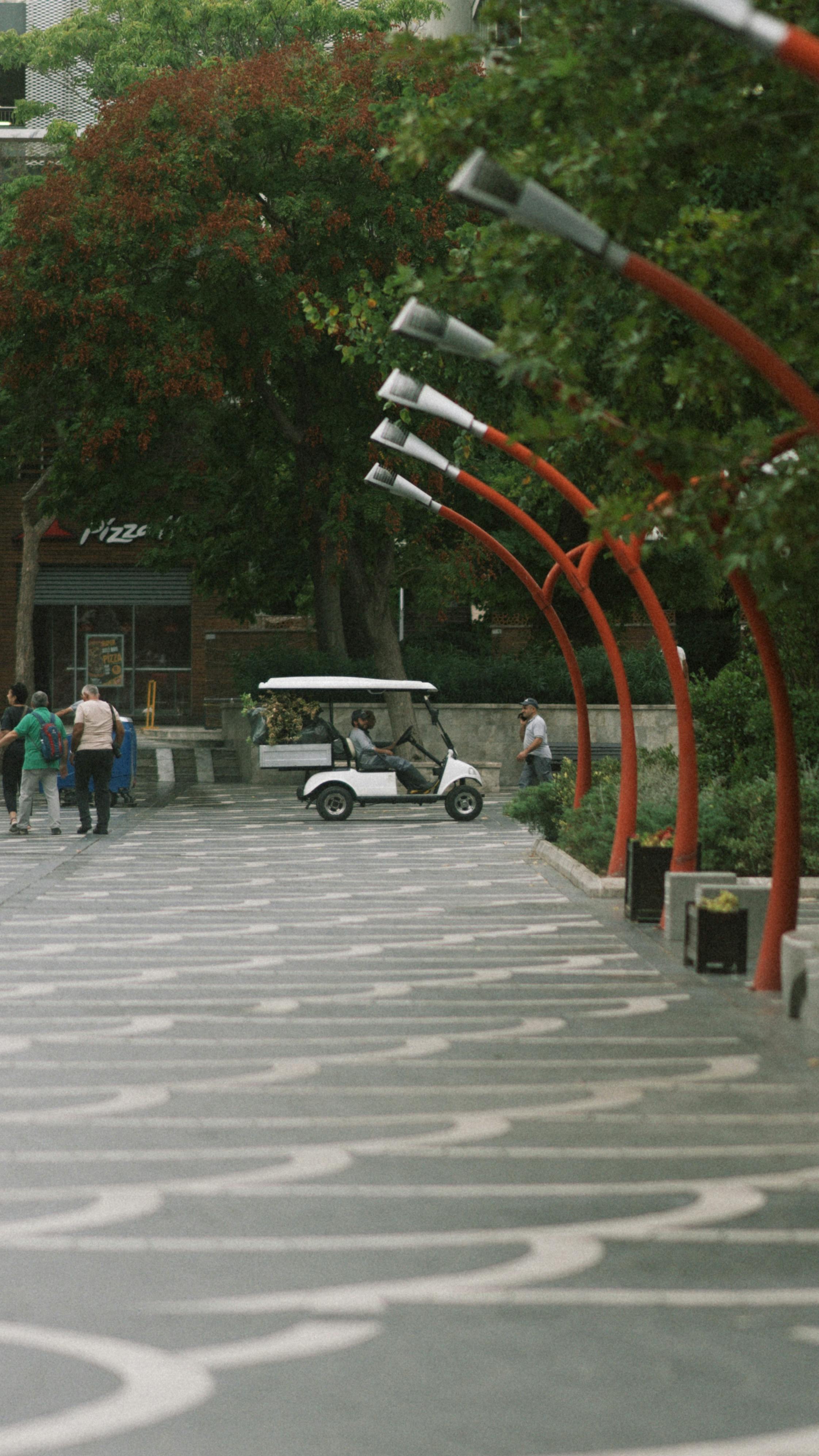 Electric Golf Cart Running on Walkway · Free Stock Photo