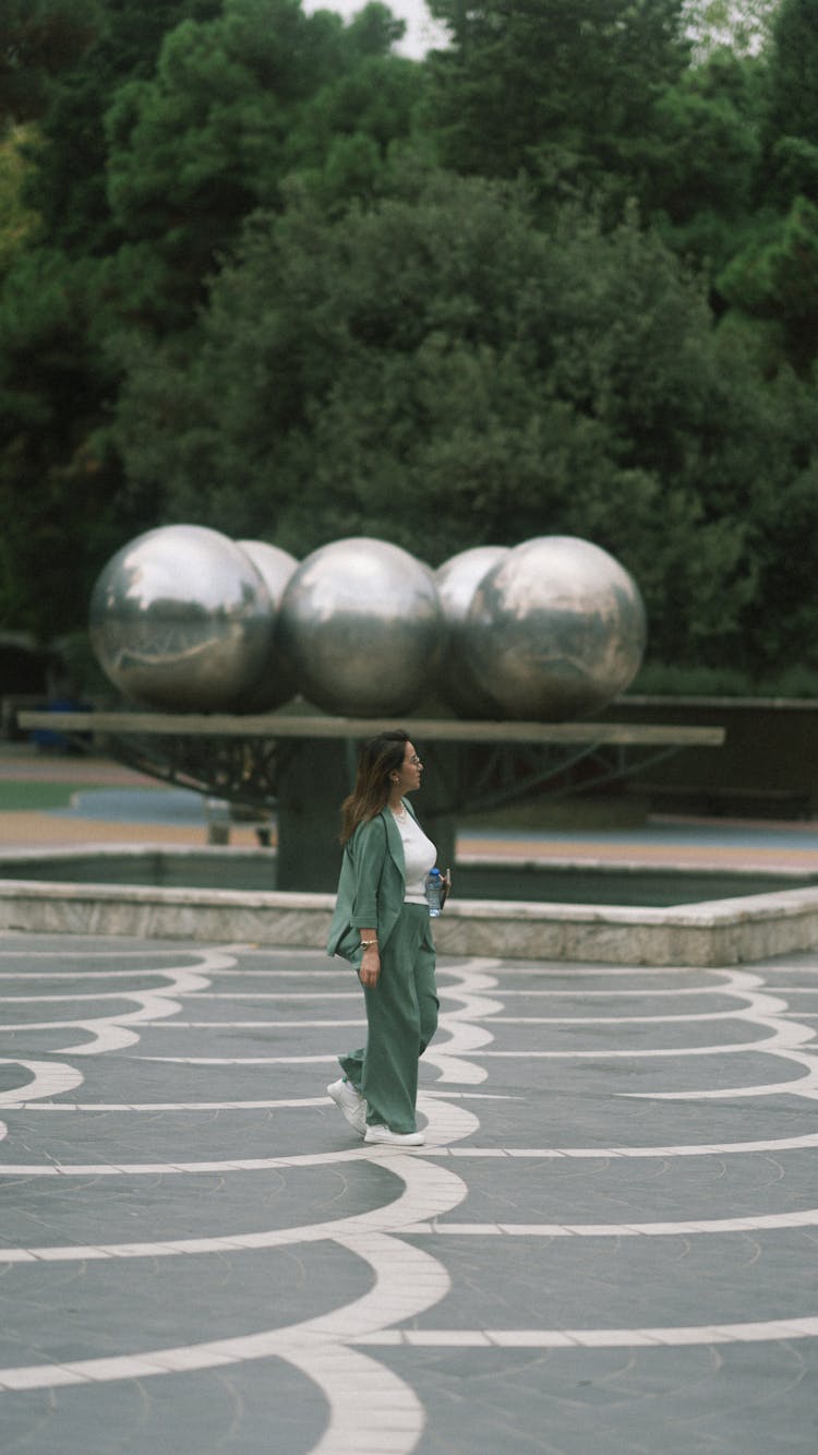 Woman Walking By Modern Sculpture Stand In Park