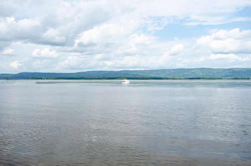 Free Tranquil view of a river with hills and a yacht in Ottawa, Canada. Stock Photo