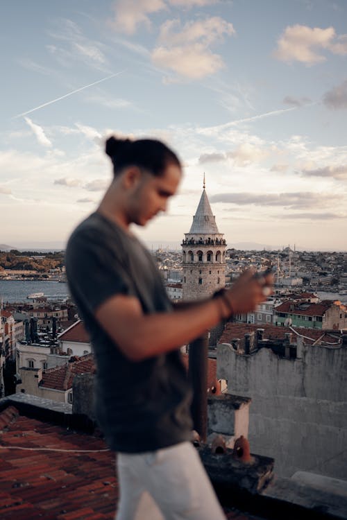 Man Controlling a Drone from a Roof near Galata Tower in Istanbul