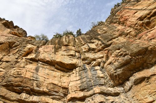 Free Close-up of a rugged cliff with stratified sandstone layers and erosion patterns in natural light. Stock Photo