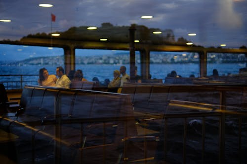 Reflection of Passengers on Seats on Ship in Window