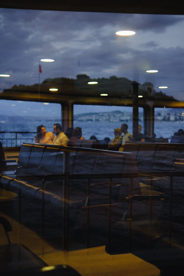 People Sitting On Rows Of Chairs In A Passenger Ferry Boat