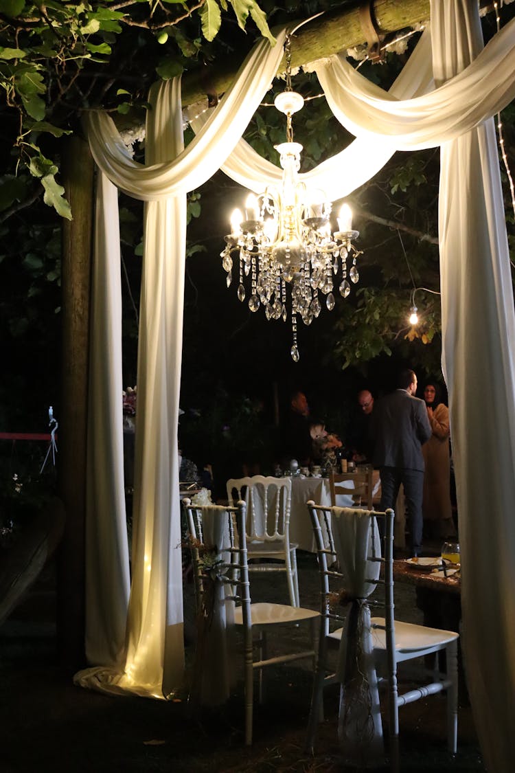 People Talking At A Luxury Pavilion With A Crystal Chandelier Lamp