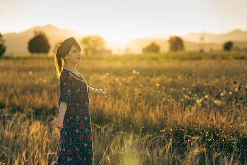 Woman in Ethnic Dress in Field on Sunset