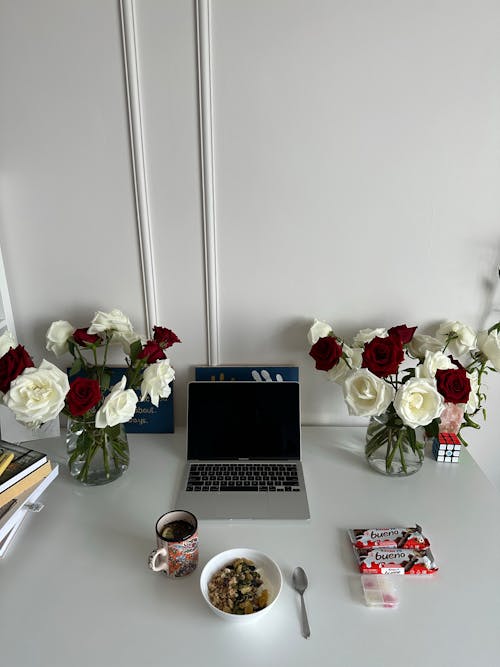 Kostnadsfri bild av bärbar dator, blommor, bord