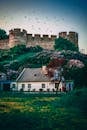 迷人的小屋坐落在历史悠久的城堡城墙下，四周绿意盎然，天空充满活力