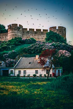 迷人的小屋坐落在历史悠久的城堡城墙下，四周绿意盎然，天空充满活力