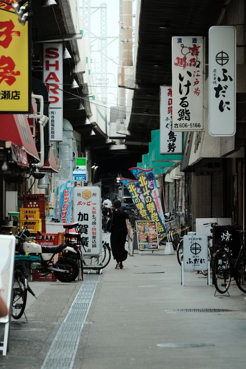 Free Bustling street in Tokyo lined with shops and signage, capturing daily urban life and culture. Stock Photo