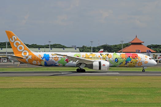 A vibrant Scoot airline Boeing 787 aircraft with Pokemon livery parked at a runway under a clear sky.