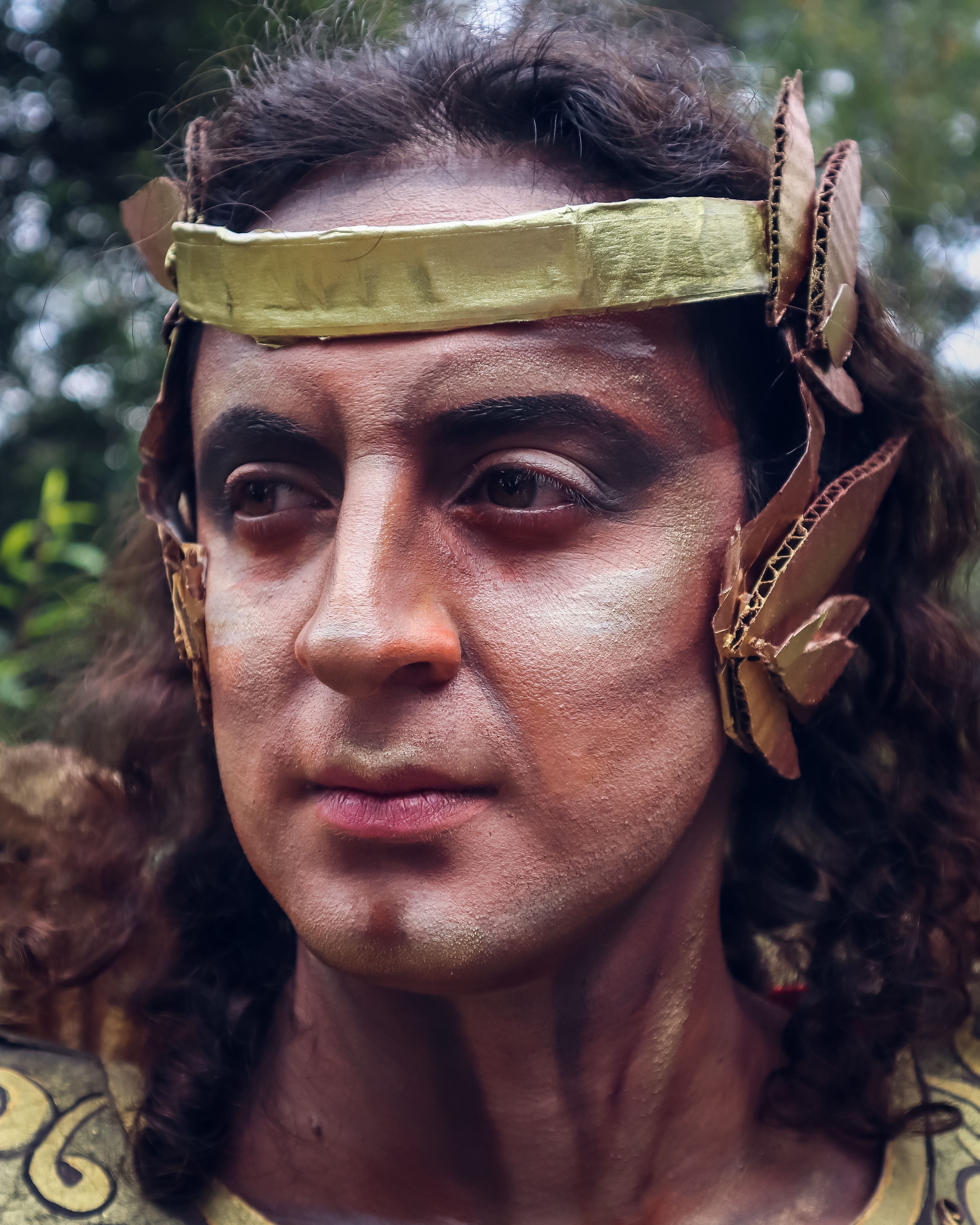 Close-up portrait of a man in traditional warrior attire with antique style makeup and costume.