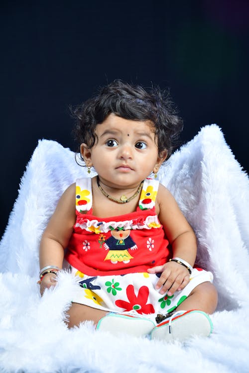 Portrait of a Cute Baby Girl Sitting on a Blanket