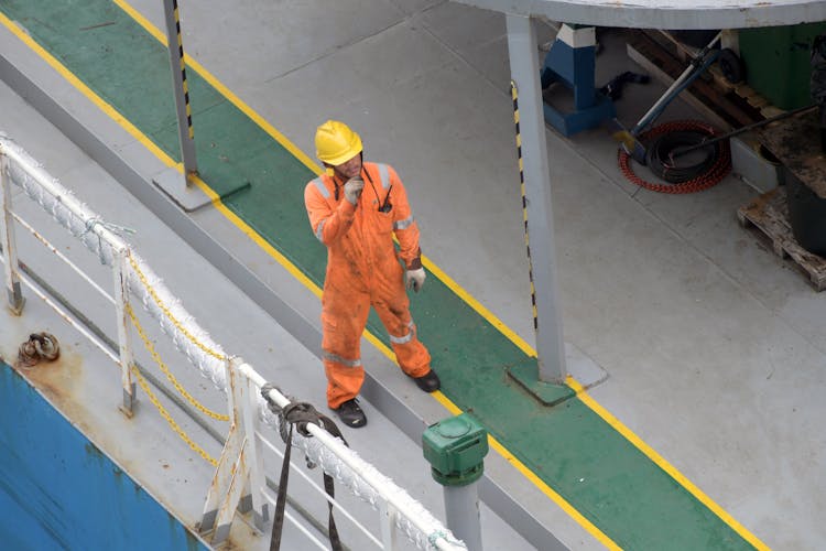 Worker In Uniform And Helmet On Road