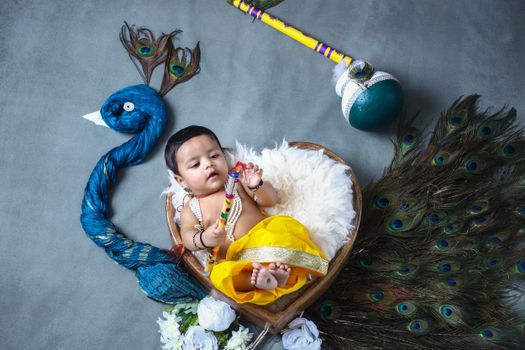 Baby Boy Lying Down in Bed in Heart Shape and with Peacock around
