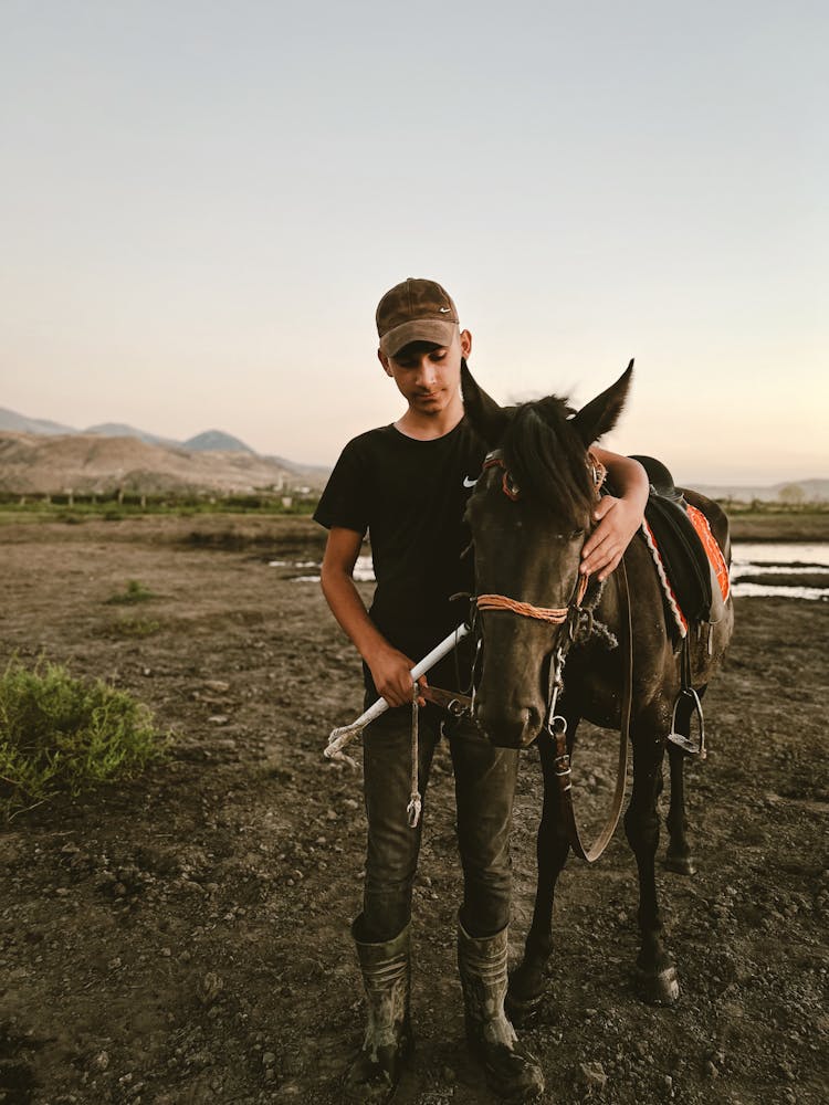 Young Man With Horse In Countryside