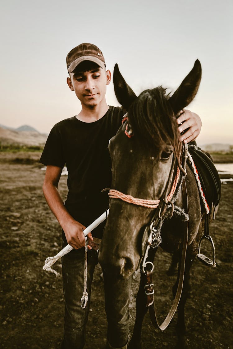 Young Man With Horse In Field