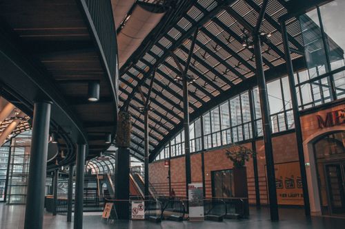 Free Architectural view of a modern train station interior with escalator and glass roof. Stock Photo