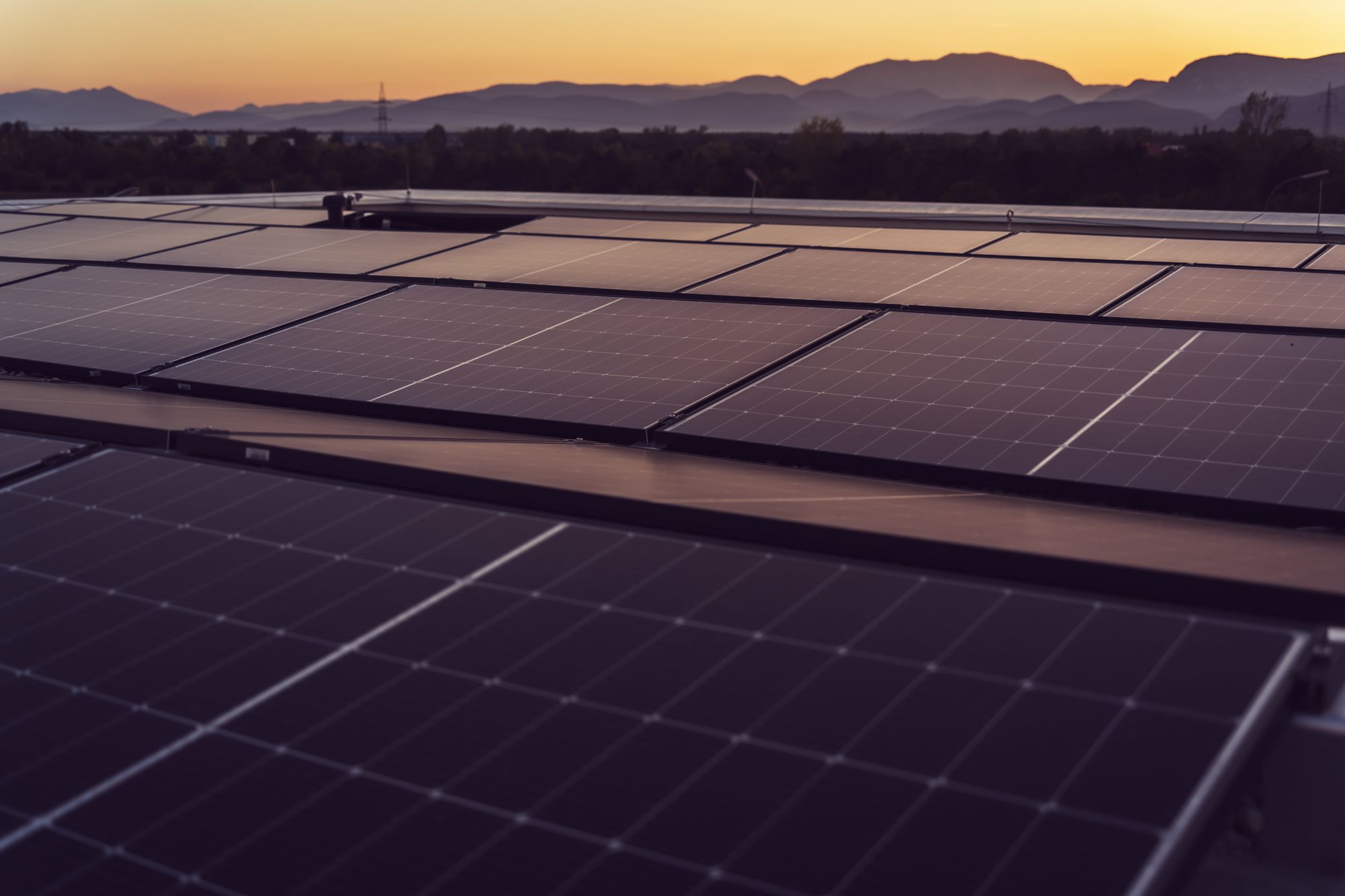 Solar panels in Styria, Austria under a serene sunset, showcasing renewable energy.