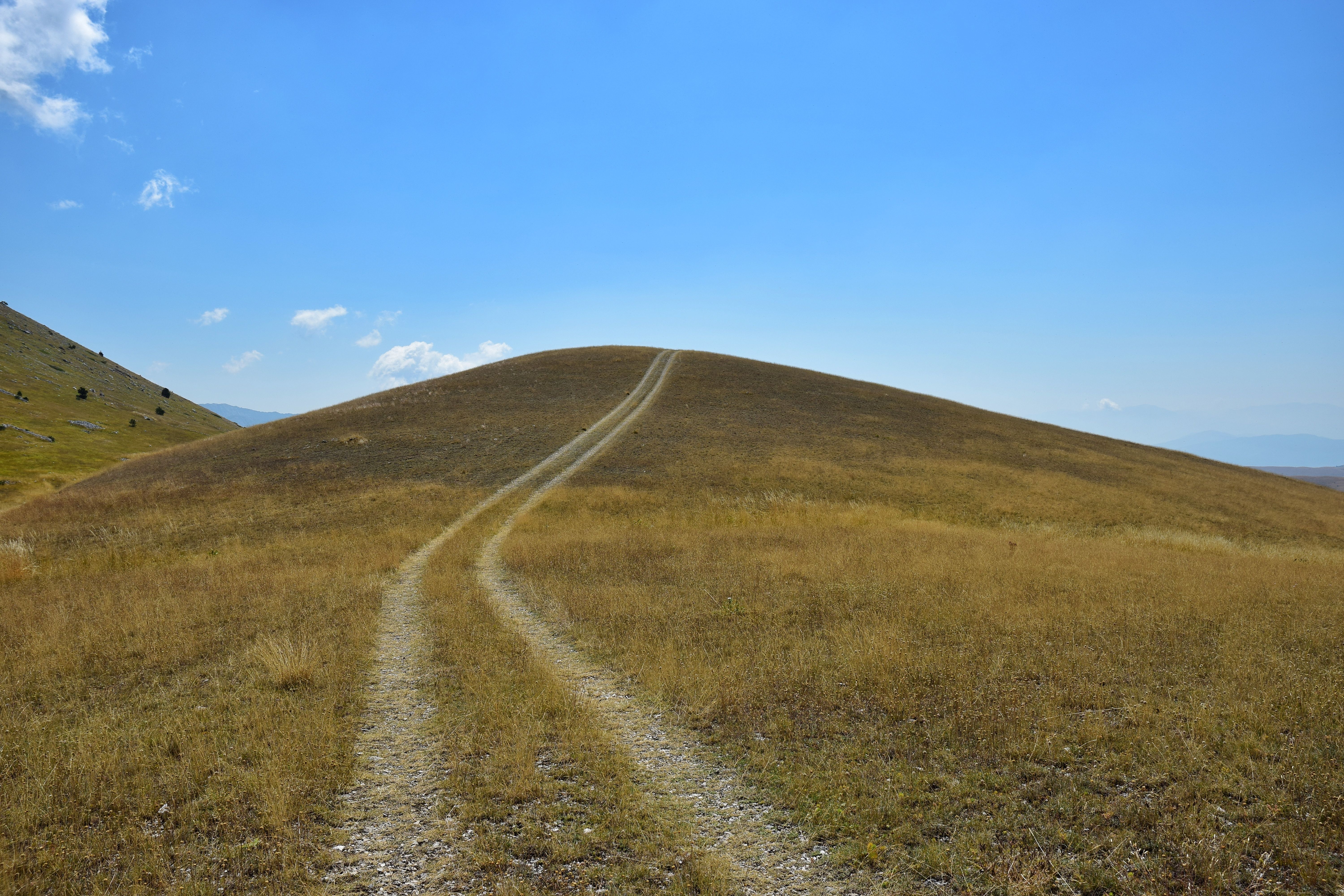 Car Tracks on Hill in Countryside against Blue Sky · Free Stock Photo