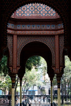 Ornate arches of Morisco Kiosk in a vibrant Mexico City park setting.