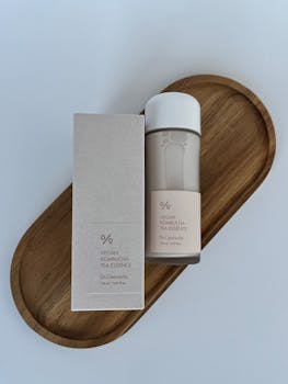 Elegant display of vegan kombucha tea essence on wooden tray, ideal for skincare use.