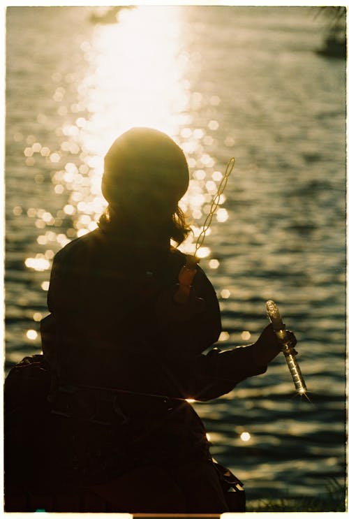 Silhouette of Woman Blowing Bubbles by the Sea