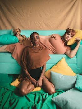 两名女子与一只狗在室内时尚地摆着姿势，展示着鲜艳的色彩