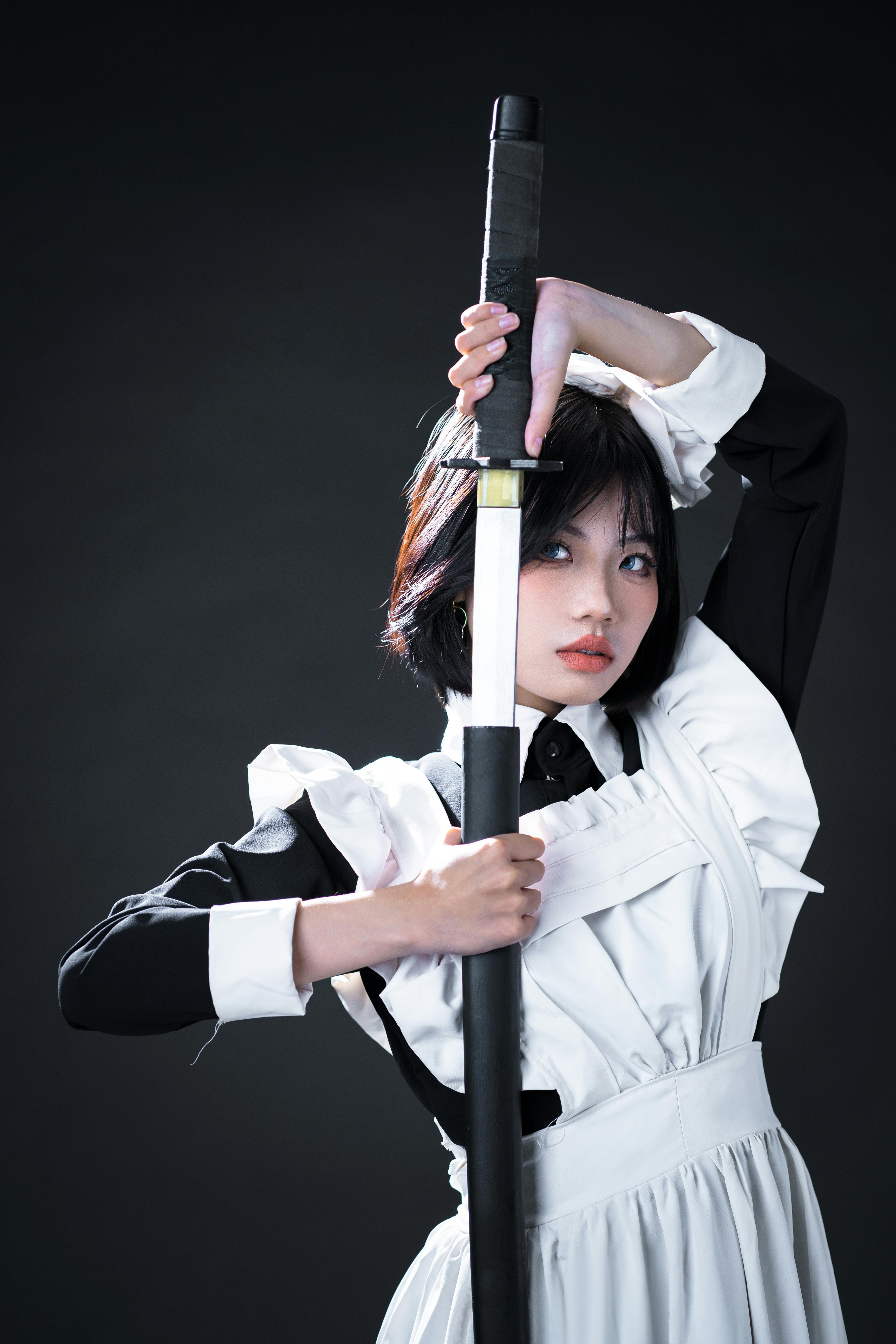 Photo of a Girl Posing with a Sword against Yellow Background · Free ...