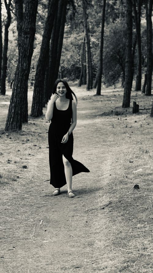 Free Black and white portrait of a woman strolling in a wooded area, capturing nature and serenity. Stock Photo