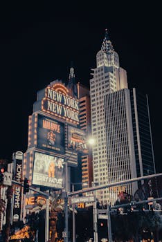 Night view of the iconic New York-New York Hotel in Las Vegas with brilliant lights and modern architecture.