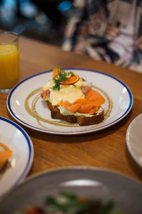 Free Fresh salmon toast served with a glass of orange juice on a wooden table in Berlin. Stock Photo