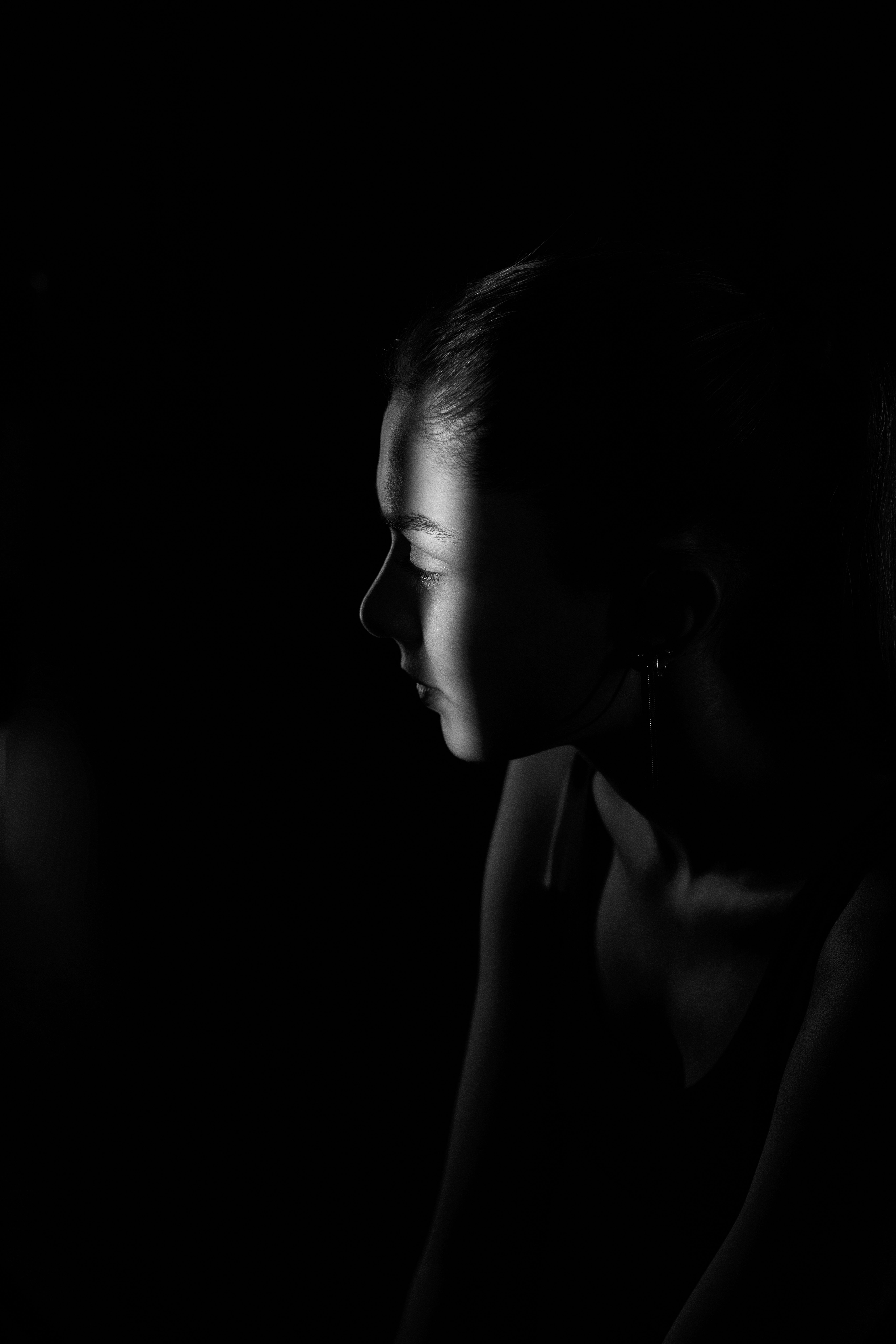 Young Woman in a Dark Room with a Streak of Light on Her Face · Free ...