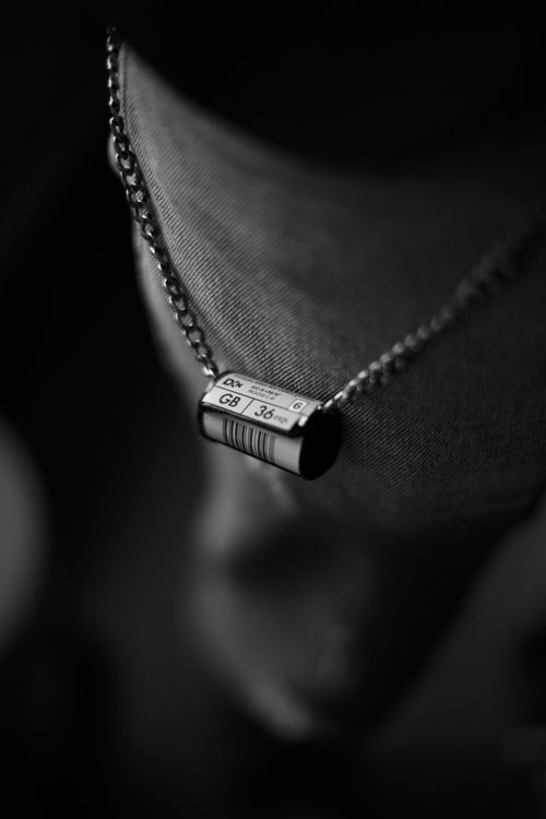 Free Close-up of vintage film roll pendant on chain, capturing retro style in Baku. Stock Photo