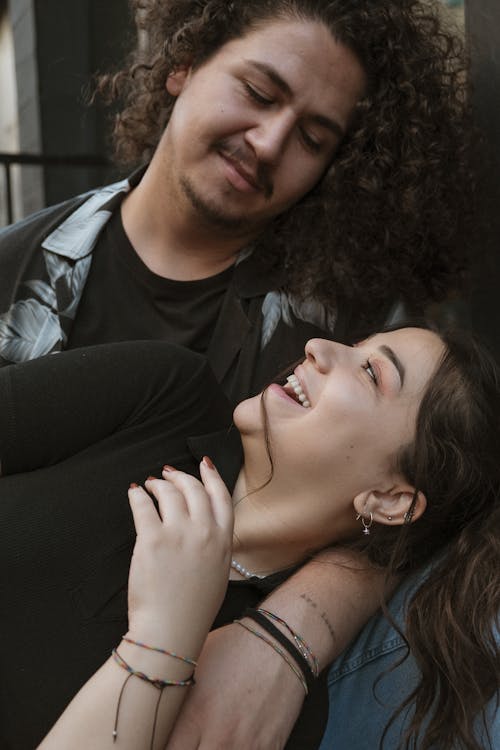 Smiling Woman Looking into Her Boyfriend Eyes Lying on His Lap