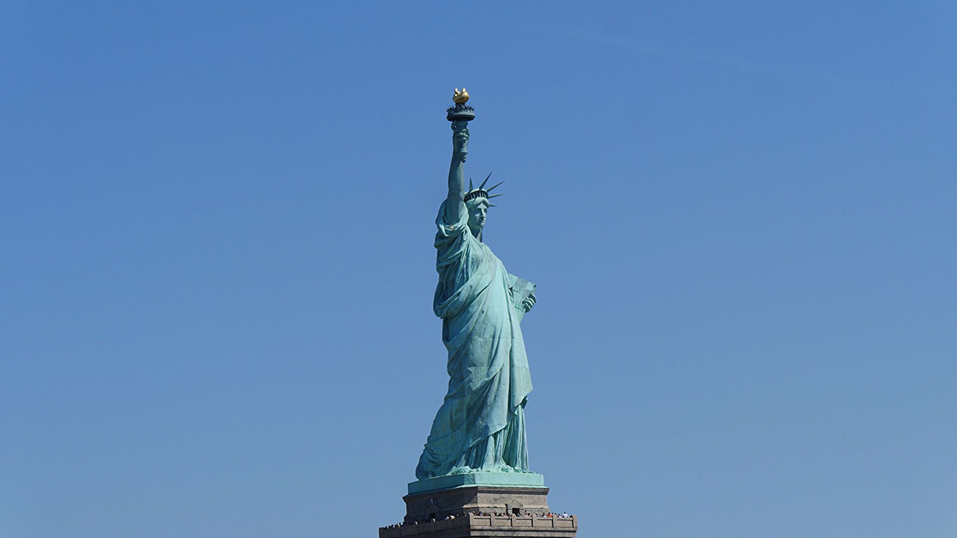 Iconic Statue of Liberty stands against a clear blue sky in New York City, USA.