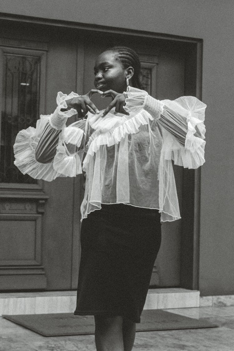 Woman In Lace Blouse And Dress Showing Heart Gesture