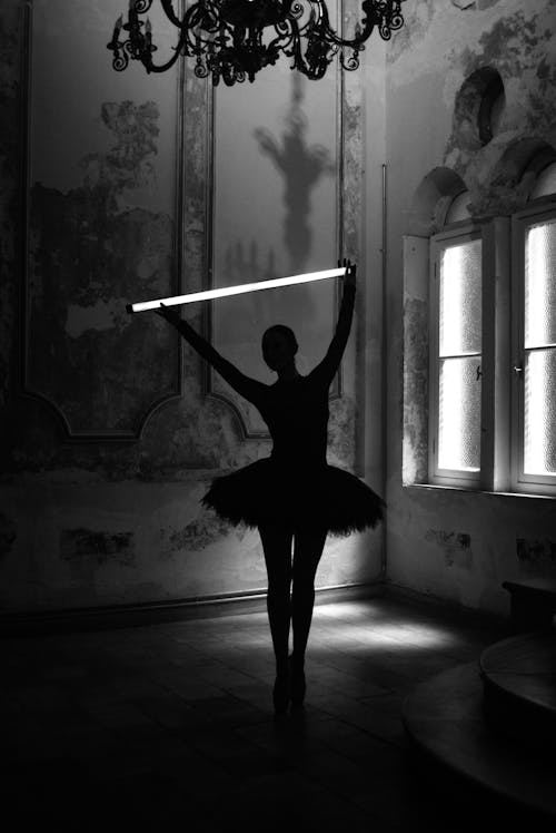 Black and White Picture of a Ballerina in a Palace Holding a Glow Stick