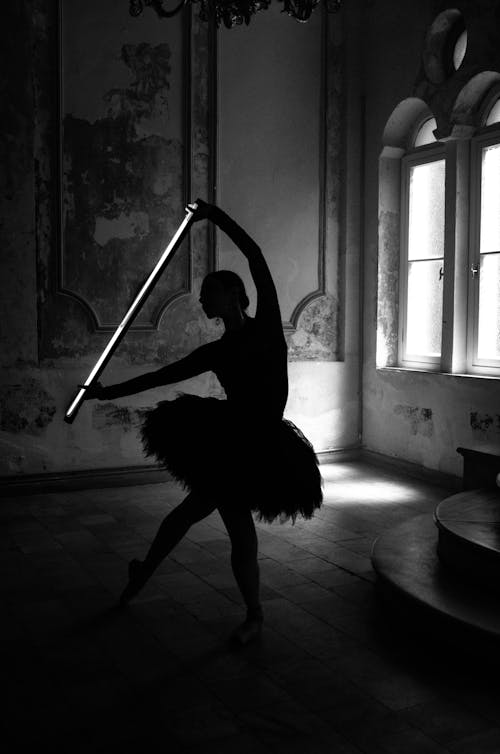 Black and White Picture of a Ballerina in a Palace Holding a Glow Stick